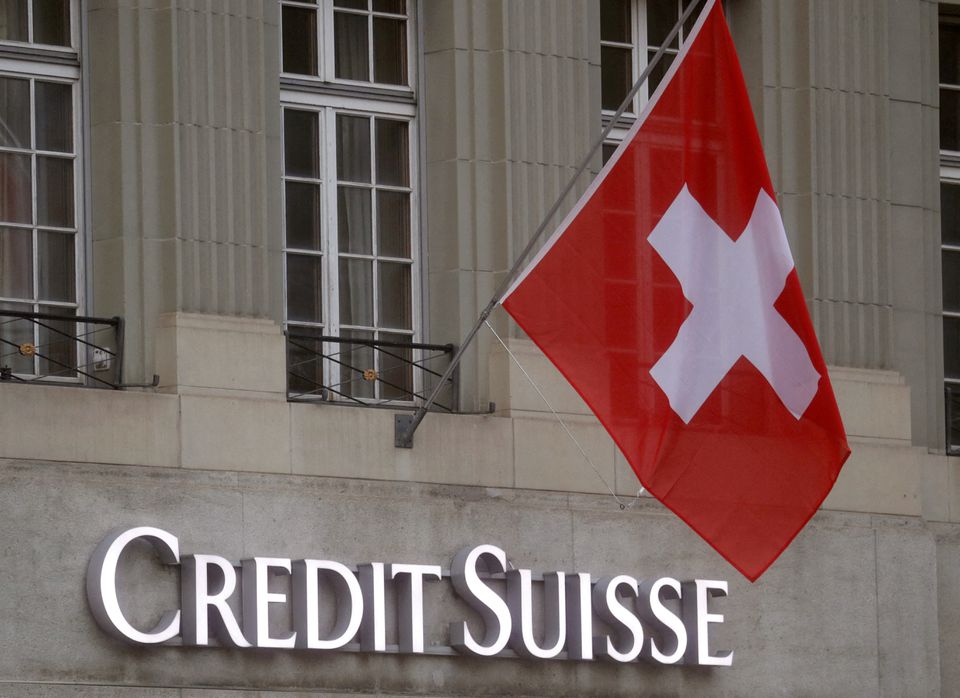 Quốc kỳ Thụy Sĩ tung bay phía trên logo của ngân hàng Thụy Sĩ Credit Suisse